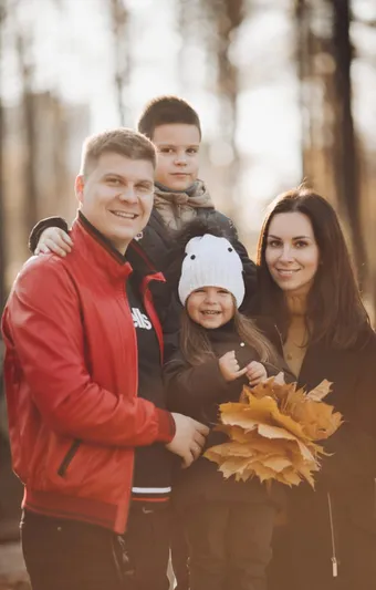Happy family reunited in Canada holding a maple leaf